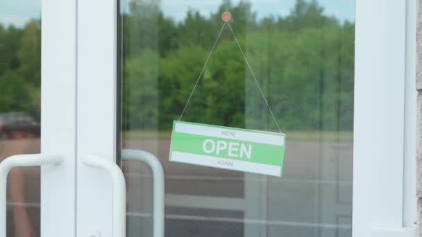 Stängt för affärer på grund av covid. Liten butik sätter upp stängd skylt på skyltfönster — Stockvideo
