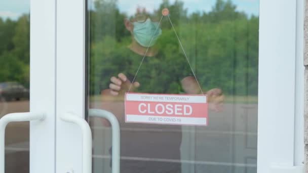我々はcovidの後に開いているサイン。私たちはガラスの扉にサインを開いています — ストック動画
