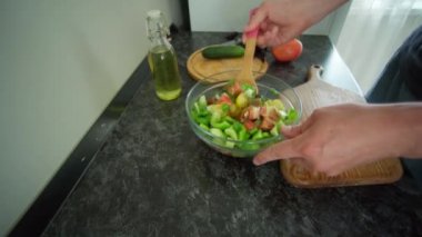 Adam siyah masada salata hazırlıyor.