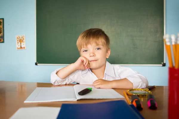 School and education concept. Little children at school lesson. Happy student writing in notebook in school classroom. Back to school concept