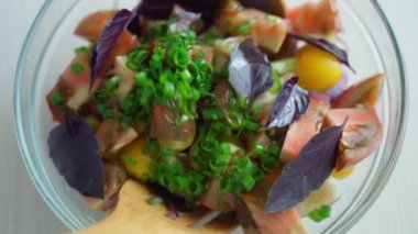 Cam kaşıklarla karıştırılmış sebze salatası.