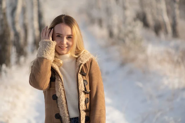 Menina bonita em uma floresta gelada de inverno em um dia ensolarado — Fotografia de Stock