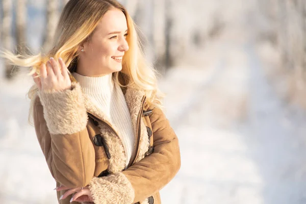 Beautiful girl in a frosty winter forest on a sunny day — Stok fotoğraf