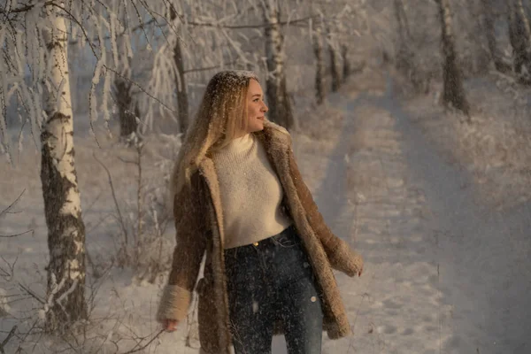 Beautiful girl in a frosty winter forest on a sunny day — Stok fotoğraf