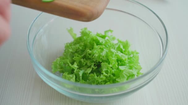 Kocken lägger gurkorna från skärbrädan i salladen — Stockvideo