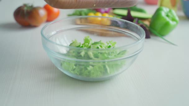 Шеф-кухар кладе огірки з обробної дошки в салат — стокове відео