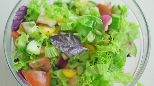 Salz wird in eine Schüssel mit Gemüsesalat gegossen — Stockvideo