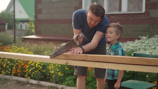 Menuisier avec son fils travaillant à l'extérieur près de la maison — Video