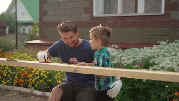 Erkek marangoz ve oğlu evin dışında çalışıyor. — Stok video