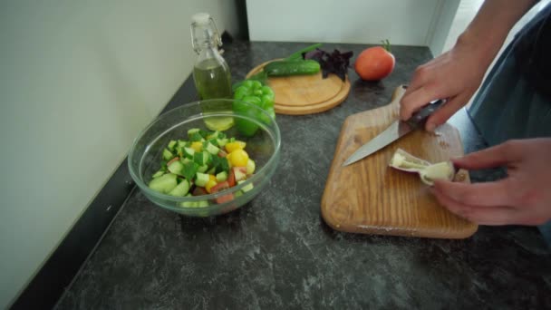 Homme préparant la salade dans la cuisine sur une table noire — Video