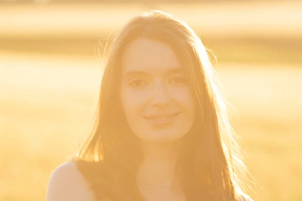 Fille dans une robe dans un champ de blé au coucher du soleil — Photo