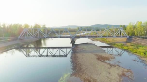 Съемка с воздуха железнодорожного моста через реку в горах — стоковое видео