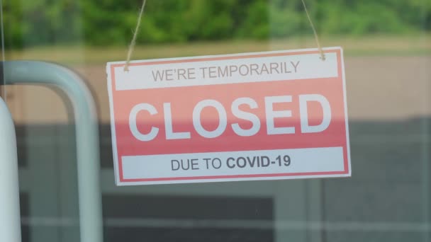 Pria itu mengubah tanda CLOSED untuk tanda OPEN. Plat informasi pada pintu transparan atau di depan toko selama pandemi COVID-19 — Stok Video
