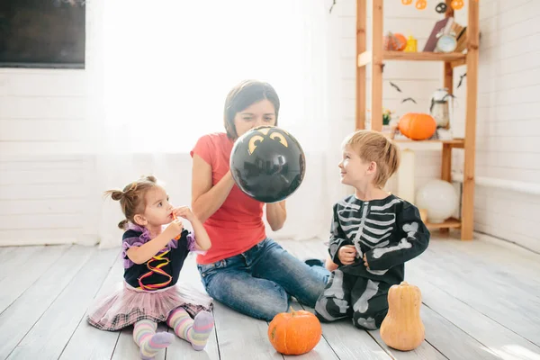 母と子供の幸せな家族は家を飾るためにハロウィーンの準備をします — ストック写真