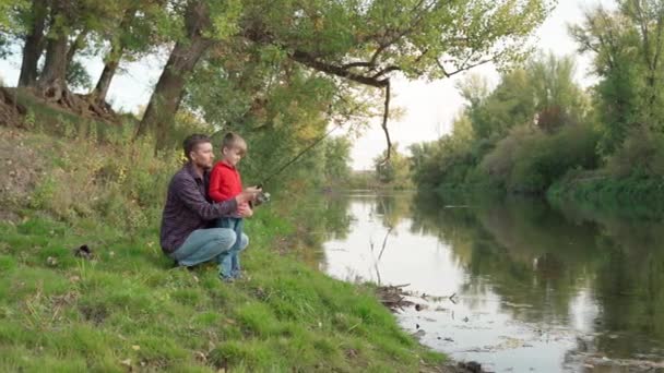 Baba oğluna balık tutmayı öğretiyor. — Stok video