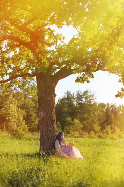 Kvinne leser bok i parken – stockfoto