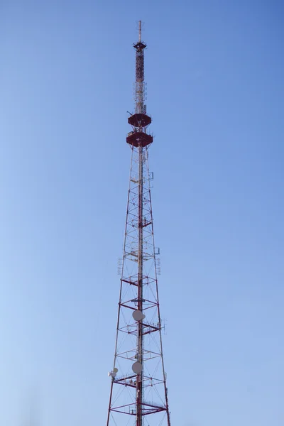 Komunikační věž proti neúprosné modrá obloha — Stock fotografie