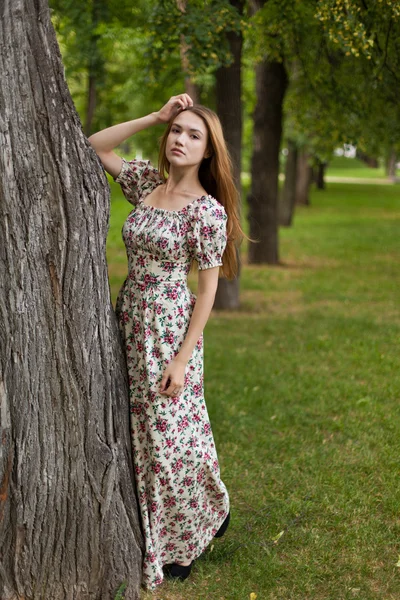Vacker ung kvinna som ler i parken — Stockfoto
