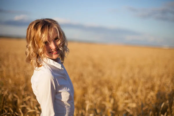 Mujer en el campo de trigo al atardecer — Foto de Stock