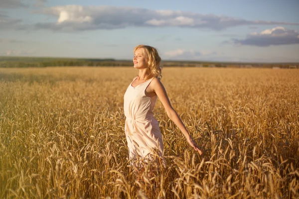 Mujer en el campo de trigo al atardecer —  Fotos de Stock
