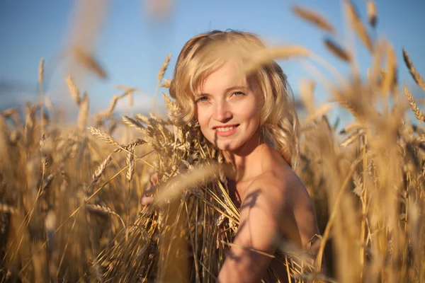 Mooie jonge vrouw in zomer weide bij gele zonsondergang — Stockfoto