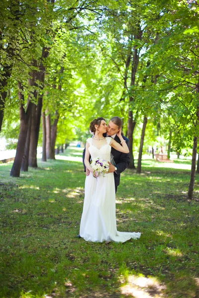 Glückliche Braut umarmt Bräutigam — Stockfoto