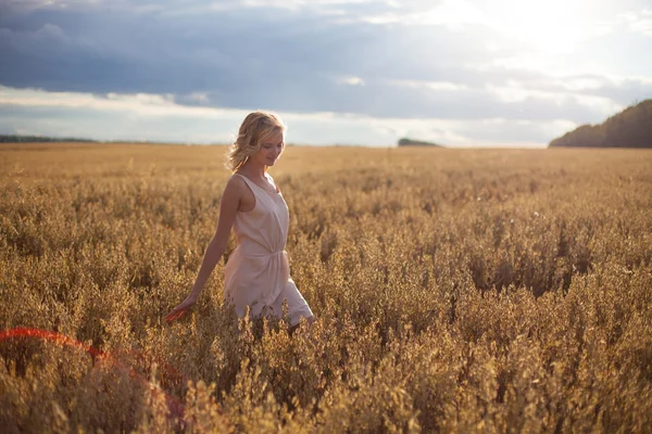 Junge Frau steht im Weizenfeld — Stockfoto