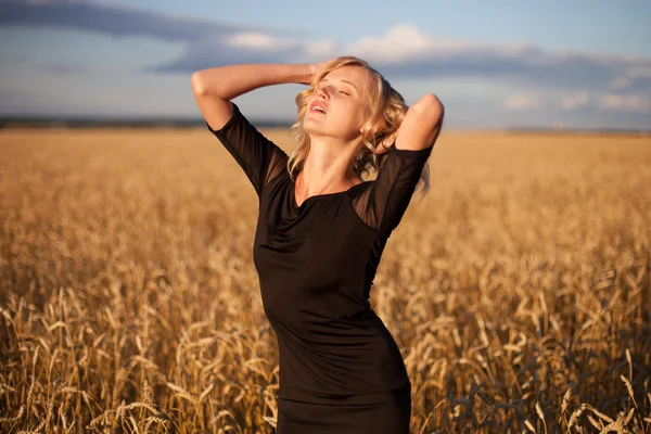 Femme dans le champ de blé au coucher du soleil — Photo