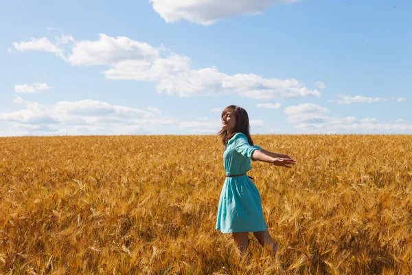 Frau hebt Arme und genießt Sonnenlicht auf Feld — Stockfoto