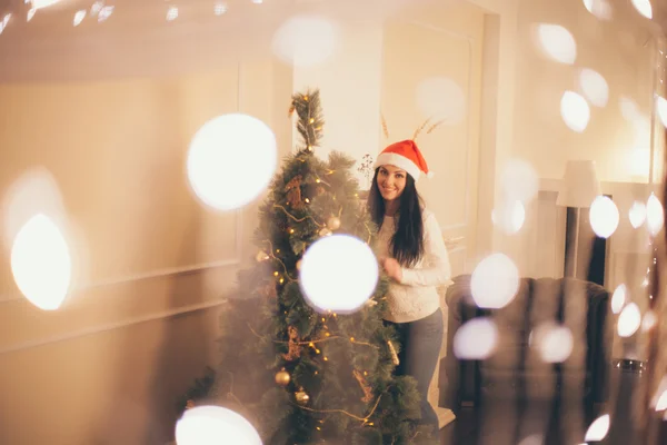 Ευτυχισμένη γυναίκα στολίζει χριστουγεννιάτικο δέντρο — Φωτογραφία Αρχείου