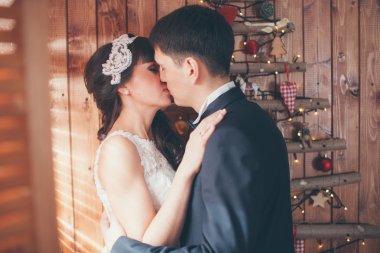 Yeni evli bir Noel ağacının yanında öpüşme. 