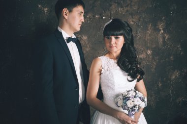 Karanlık duvarlar arka plan üzerinde yeni evliler.