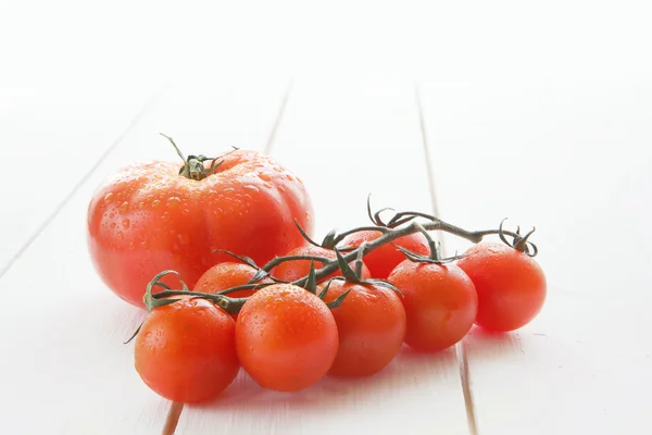 Tomaten op een wit hout tabel achtergrond. — Stockfoto