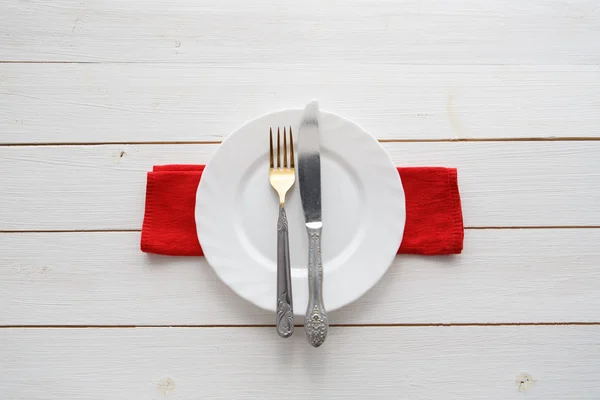 Faca, garfo e prato sobre mesa de madeira — Fotografia de Stock