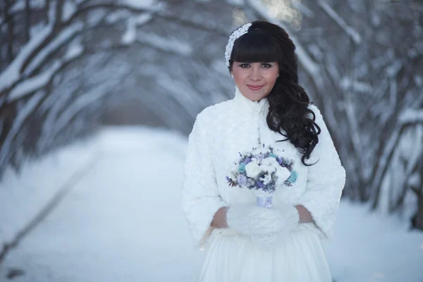 Mooie bruid met een boeket in de winter — Stockfoto