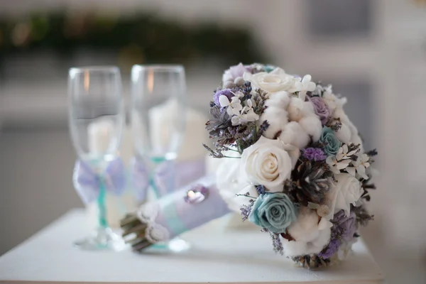 Winter wedding bouquet near glasses. — Stock Photo, Image