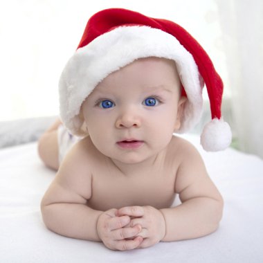 Noel 'de beyaz, yumuşak ekose üzerinde uzanan tatlı erkek bebek.