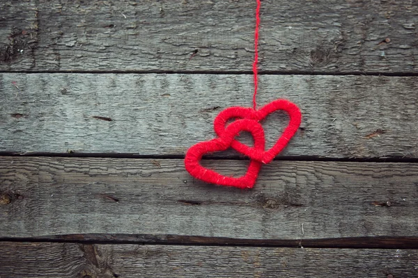 Dos corazones rojos sobre un viejo fondo de madera en mal estado — Foto de Stock