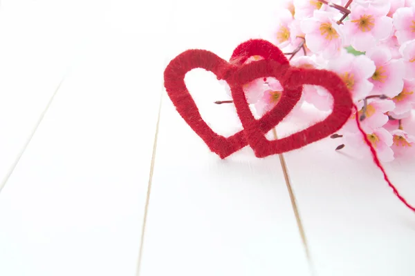 Dos corazones con flores de flor de cerezo de primavera sobre fondo de madera — Foto de Stock