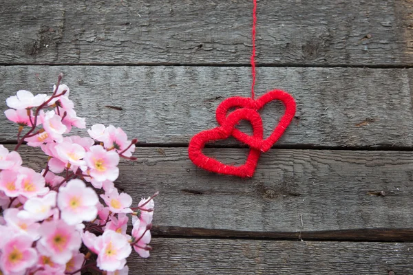 Dois corações com flores de cereja primavera em fundo de madeira — Fotografia de Stock