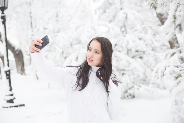 Mulher tirando uma foto no parque de inverno — Fotografia de Stock