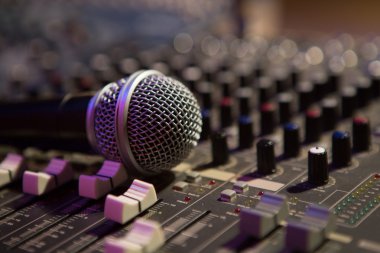 Microphone resting on a sound console clipart