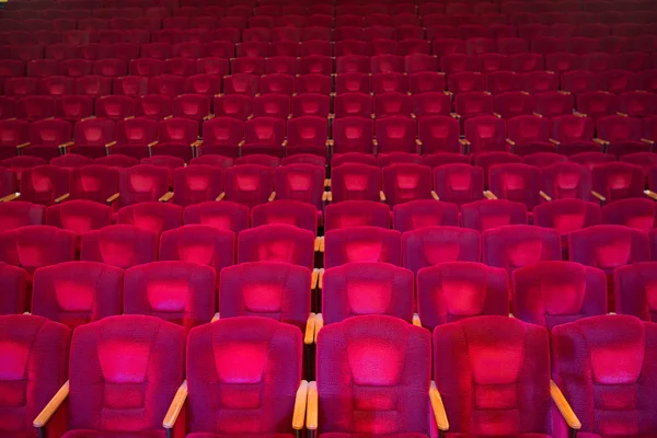 Red velvet armchairs in the empty auditorium — Stock Photo, Image