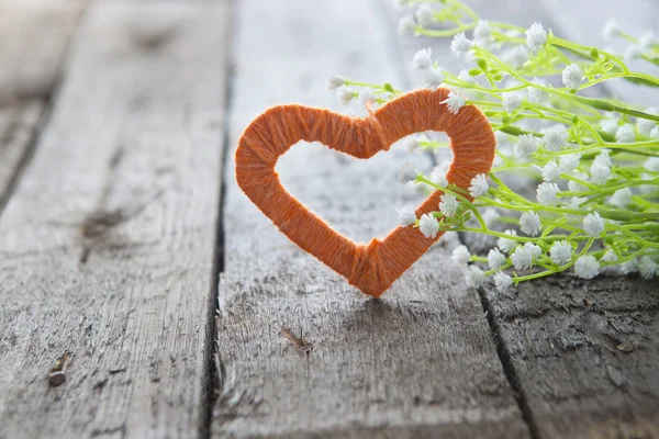 Hjärta och vita blommor på ett gammalt träbord. — Stockfoto