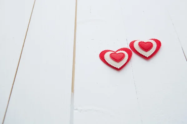 Dois corações pendurados no fundo de madeira pintado branco — Fotografia de Stock