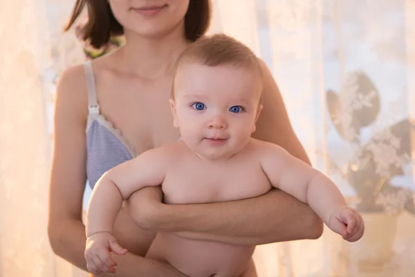 Mãe com bebê no quarto em casa perto da janela — Fotografia de Stock