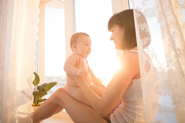 Anne ve bebek pencerenin önünde yakın: — Stok fotoğraf