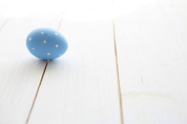 Beyaz eski ahşap masa üstünde mavi yumurta