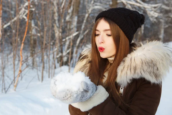 Menina de inverno beleza soprando neve no parque de inverno gelado . — Fotografia de Stock