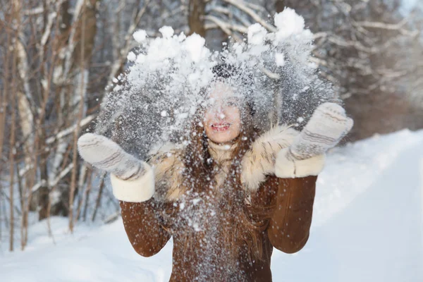 Mujer en una gorra negra lanzando bola de nieve — Foto de Stock